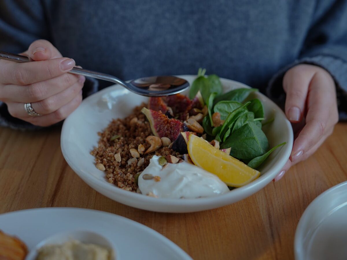 A vibrant brunch bowl with fruit, greens, and nuts for a nutritious meal.